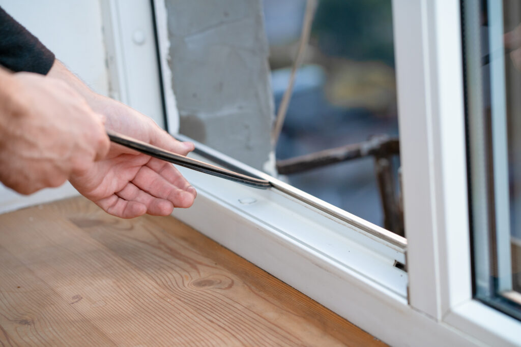 Präzise Handwerkskunst: Mitarbeiter setzt Fensterdichtungen ein, um Effizienz und Wohlbefinden zu maximieren.